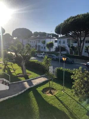 a view of a street with trees and houses at Calma La Barrosa Apartamento in Chiclana de la Frontera