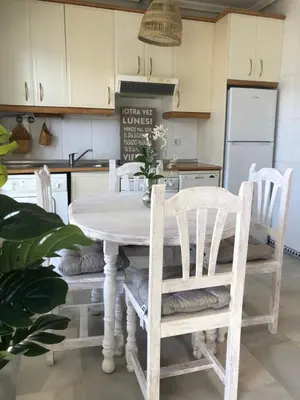 a kitchen with a wooden table and chairs at Calma La Barrosa Apartamento in Chiclana de la Frontera