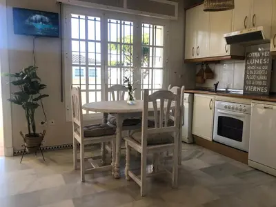 a kitchen with a table and chairs in a kitchen at Calma La Barrosa Apartamento in Chiclana de la Frontera