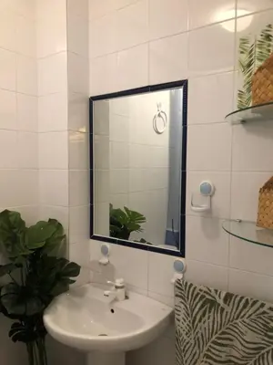 a white bathroom with a sink and a mirror at Calma La Barrosa Apartamento in Chiclana de la Frontera