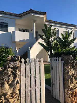 a white fence in front of a house at Calma La Barrosa Apartamento in Chiclana de la Frontera