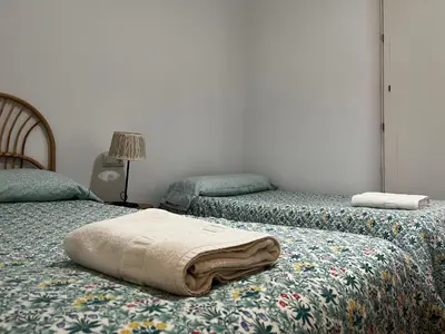 a bedroom with two beds with towels on them at Casa Ayuntamiento Ascensor Grupo AC Gestion in Cádiz
