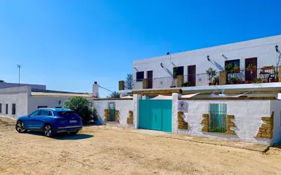 a blue car parked in front of a building at Conil Colorado 1 rústico y económico in Conil de la Frontera