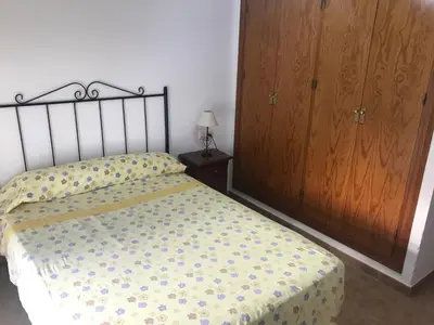 a bedroom with a bed and a wooden cabinet at Conil, Colorado 2 rustico y económico in Conil de la Frontera