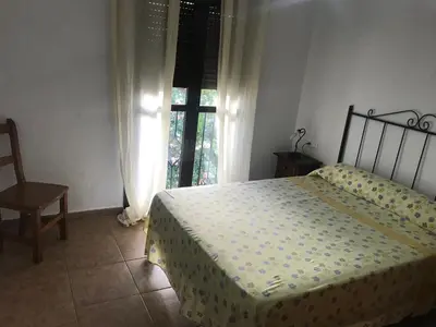 a bedroom with a bed and a window at Conil, Colorado 2 rustico y económico in Conil de la Frontera