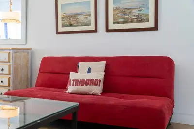 a red couch with a pillow on it in a living room at Apartamento Puerto Sherry in El Puerto de Santa María