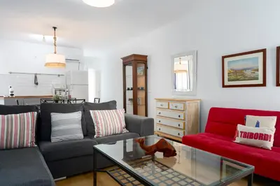 a living room with two couches and a red couch at Apartamento Puerto Sherry in El Puerto de Santa María
