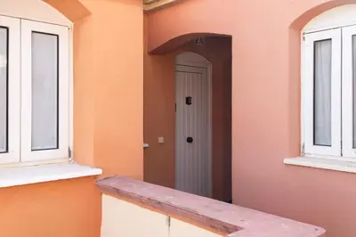 an orange building with a white door and two windows at Apartamento Puerto Sherry in El Puerto de Santa María