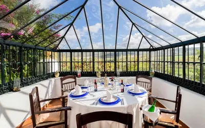 a dining room with a table in a glass house at Hacienda El Santiscal in Arcos de la Frontera
