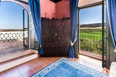 a room with a door open to a balcony at Hacienda El Santiscal in Arcos de la Frontera