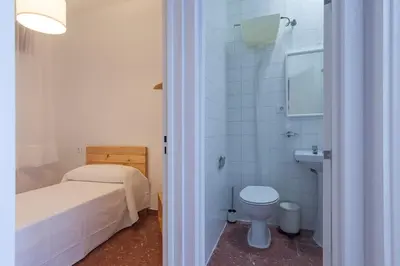 a bathroom with a bed and a toilet and a sink at Precioso y luminoso apartamento Calle Corredera. Casco Histórico in Arcos de la Frontera