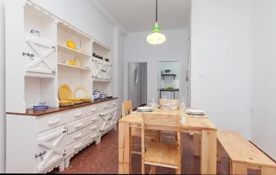 a kitchen with a wooden table and white cabinets at Precioso y luminoso apartamento Calle Corredera. Casco Histórico in Arcos de la Frontera