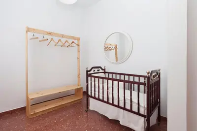 a baby crib and a mirror in a room at Precioso y luminoso apartamento Calle Corredera. Casco Histórico in Arcos de la Frontera