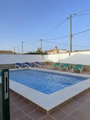 a swimming pool with lawn chairs and a swimming pool at CASA SUROESTE in Conil de la Frontera
