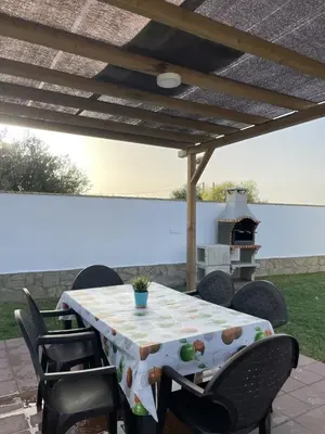 a table with chairs and a grill on a patio at CASA SUROESTE in Conil de la Frontera