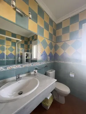 a bathroom with a sink and a toilet and a mirror at CASA SUROESTE in Conil de la Frontera