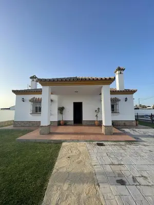 a white house with a door and a yard at CASA SUROESTE in Conil de la Frontera