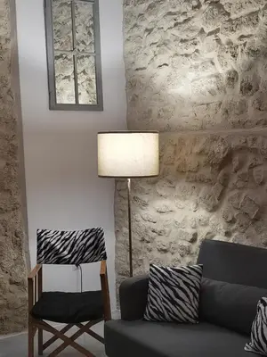 a living room with a couch and a lamp and a chair at Ático Plaza 9 by casitasconencantoes in Medina Sidonia
