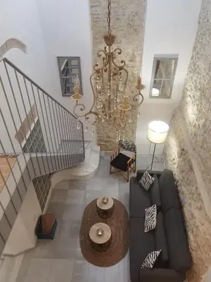 a living room with a couch and a chandelier at Ático Plaza 9 by casitasconencantoes in Medina Sidonia