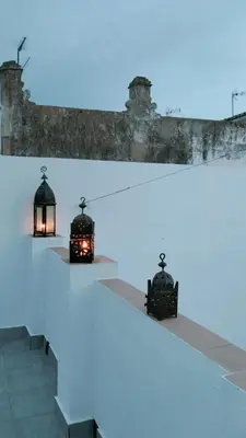 two lights on a table in front of a building at Ático Plaza 9 by casitasconencantoes in Medina Sidonia