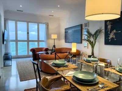 a living room with a table and chairs and a couch at Las Marinas de la Bahia in Cádiz
