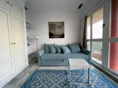 a living room with a blue couch and a table at Las Marinas de la Bahia in Cádiz