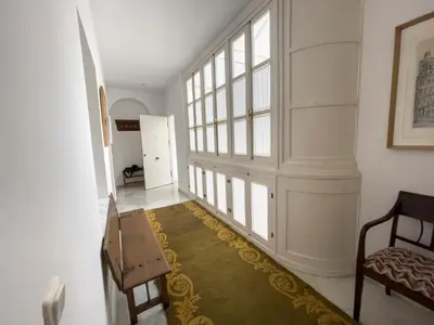 a hallway with two chairs and a large window at Las Marinas de la Bahia in Cádiz