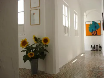 a vase filled with sunflowers in a hallway at La Casa Grande in Arcos de la Frontera
