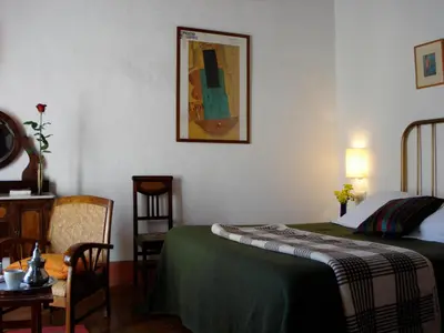 a bedroom with a bed and a table and a chair at La Casa Grande in Arcos de la Frontera