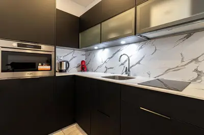 a kitchen with black cabinets and a sink at Allo Apartments San Roque Bajo A in Cádiz