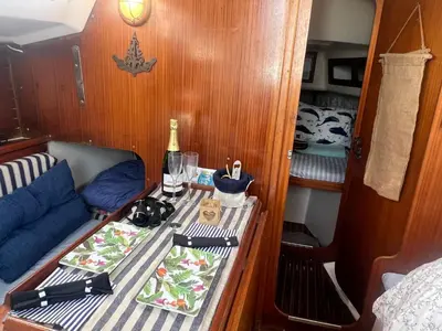 a small boat with a table with a bottle of wine at Velero en el corazón de El Puerto de Santa María in El Puerto de Santa María