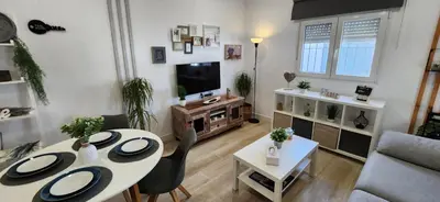 a living room with a table and a couch at Minichalet Jacaranda in Chiclana de la Frontera