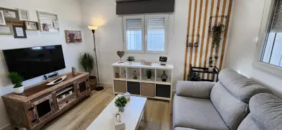 a living room with a couch and a television at Minichalet Jacaranda in Chiclana de la Frontera