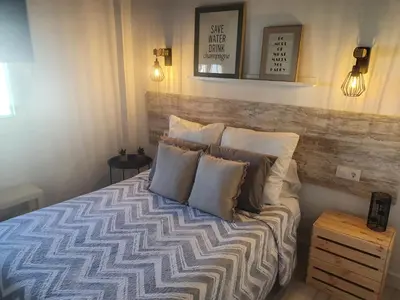 a bedroom with a bed with pillows on it at Minichalet Jacaranda in Chiclana de la Frontera