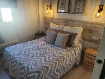 a bedroom with a large bed with pillows on it at Minichalet Jacaranda in Chiclana de la Frontera
