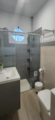 a bathroom with a shower and a toilet and a sink at Minichalet Jacaranda in Chiclana de la Frontera