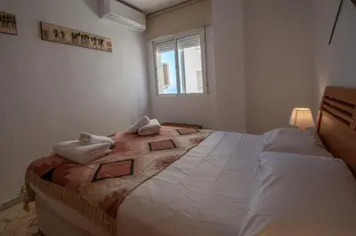 a bedroom with a large bed with towels on it at Apartamento Tribalia Cadiz in Cádiz