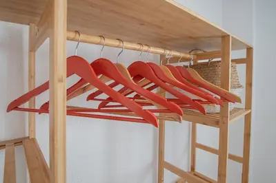 a group of red hangers on a wooden shelf at Apartamento Tribalia Cadiz in Cádiz