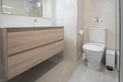 a white bathroom with a toilet and a sink at Apartamento Tribalia Cadiz in Cádiz
