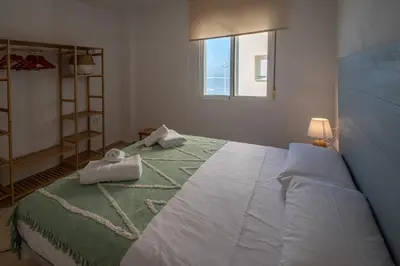 a bedroom with a large bed with towels on it at Apartamento Tribalia Cadiz in Cádiz