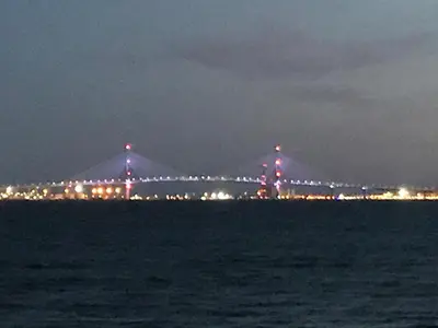 a bridge over the water at night with lights at Magnífico piso en la playa in El Puerto de Santa María