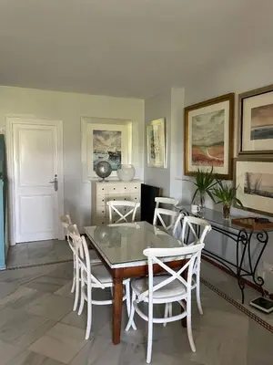 a dining room with a table and white chairs at Magnífico piso en la playa in El Puerto de Santa María