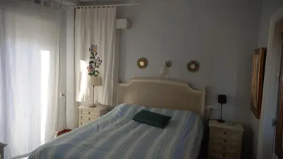 a bedroom with a bed with a green pillow on it at Magnífico piso en la playa in El Puerto de Santa María