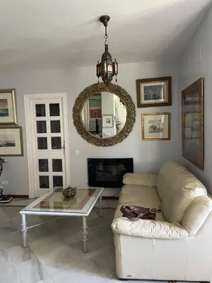 a living room with a white couch and a mirror at Magnífico piso en la playa in El Puerto de Santa María
