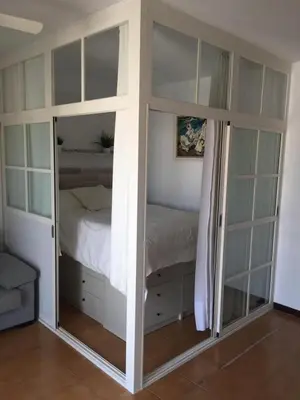 a bedroom with a bunk bed with glass doors at Valdelagrana vista al mar Puerto de Santa María in El Puerto de Santa María