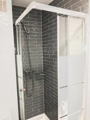 a bathroom with a shower with black tiles at Valdelagrana vista al mar Puerto de Santa María in El Puerto de Santa María