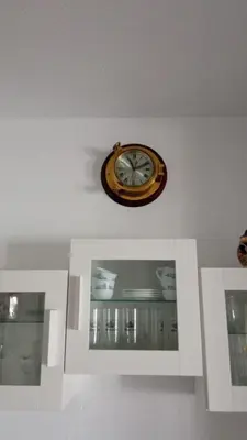 a clock on a wall above a white cabinet at Valdelagrana vista al mar Puerto de Santa María in El Puerto de Santa María