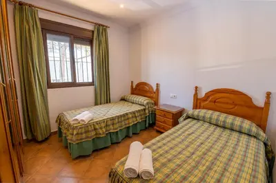 a hotel room with two beds and a window at Novobarrosa Apartamentos Turísticos in Chiclana de la Frontera