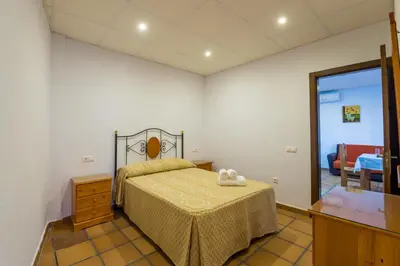 a bedroom with a bed and a dresser and a mirror at Novobarrosa Apartamentos Turísticos in Chiclana de la Frontera