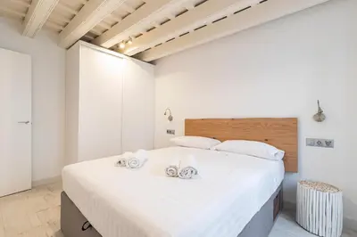 a bedroom with a large white bed with towels on it at Allo Apartments San Roque 1ºA in Cádiz